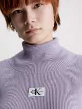 Vestido corto de punto de lyocell color lila, con cuello alto, mangas largas y corte ajustado. Presenta logo de Calvin Klein en el pecho.