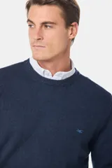 Buzo tejido de lana con escote redondo a la base y mangas largas. Presenta puños y ruedo acanalados, con un pequeño logo bordado en el pecho.