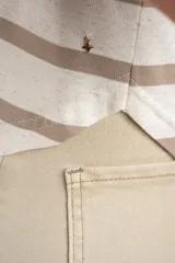 Remera de manga corta con diseño de rayas horizontales en tonos arena y blanco, de cuello redondo y corte ajustado.