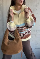 Sweater de tejido de punto con diseño a rayas horizontales y motivos geométricos, cuello alto con cierre frontal parcial, mangas largas abullonadas y puños acanalados.