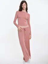 Pantalón de dormir de corte recto y holgado, confeccionado en tejido suave con textura acanalada. Presenta cintura elástica con cordón ajustable y bolsillos laterales.