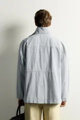 Parka relaxed fit de algodón con efecto lavado, color gris, cuello subido, manga larga y bolsillos de plastrón con solapa en el delantero. Cuenta con cierre frontal de botones y solapa.