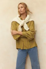 Camisa verde oliva de corte relajado, cuello clásico y mangas largas abullonadas con puños abotonados.