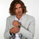 Reloj Maserati para hombre, modelo Competizione, con caja de acero plateado de 43mm de diámetro, bisel dorado, esfera negra con logo y agujas doradas, indicador de fecha y cristal mineral con lupa. Correa de acero plateado y dorado. Resistente al agua hasta 100 metros.