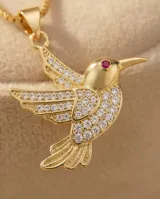 Cadena de eslabones finos con baño de oro y dije en forma de colibrí, adornado con circonias incrustadas y un detalle de piedra roja en el ojo.