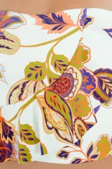 Top de bikini con escote recto y breteles finos, presenta un diseño con volado asimétrico en la base y estampado botánico multicolor sobre fondo blanco.