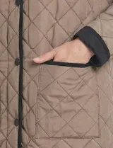 Campera reversible de corte largo con diseño capitoneado. Un lado presenta un tono verde oliva y el otro un tono negro, ambos con cierre frontal mediante botones a presión y bolsillos laterales.