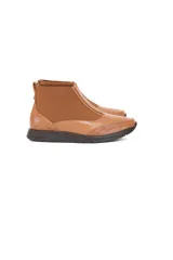 Botín Chelsea de caña baja color caramelo, confeccionado en cuero vacuno liso, tejido elástico y detalle texturizado con efecto escama en el talón y la puntera. Cuenta con suela plana oscura y diseño anatómico flexible.