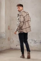 Sobrecamisa de corte holgado con diseño a cuadros en tonos azul marino y marrón, confeccionada con forro interior de corderito sintético, cuello clásico, cierre frontal de botones y bolsillos en el pecho.