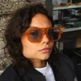 Lentes de sol con marco de acetato color naranja translúcido, diseño geométrico estilo aviador moderno y cristales oscuros con protección UV400.