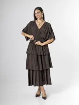 Vestido midi de crepé color marrón, con escote en V, mangas cortas amplias, cintura elastizada con lazo ajustable y falda larga escalonada con volados.