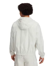 Campera deportiva Under Armour Curry Woven Jacket de color gris claro, con capucha ajustable, cierre frontal completo y bolsillos laterales. Incorpora tecnología UA Storm repelente al agua y tejido elástico ligero.