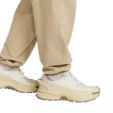 Pantalón cargo Nike de estilo deportivo, confeccionado en tejido ligero color beige. Presenta cintura elástica con cordón ajustable, bolsillos laterales tipo cargo y puños elásticos en los tobillos. Incluye el logo de la marca bordado en la parte superior.