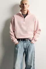 Sudadera de corte regular fit en color rosado, con cuello subido y cierre frontal de cremallera. Presenta manga larga y acabados en rib en puños y ruedo.
