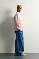 Jeans loose fit de tiro medio, confeccionados en denim de algodón color azul con efecto lavado. Presentan diseño de cinco bolsillos, bolsillo plastrón estilo carpintero en la pierna y cierre frontal con cremallera y botón.