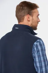 Chaleco de polar color beige con detalles en azul marino, cuello alto, cierre frontal completo y bolsillo en el pecho con cierre.