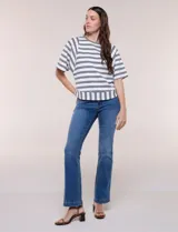 Remera de corte holgado color blanco con rayas horizontales oscuras, escote redondo a la base y mangas cortas amplias tipo murciélago. Presenta una banda ancha en el ruedo inferior con rayas verticales.