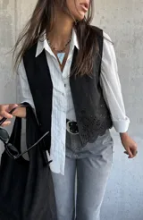 Chaleco negro de gamuza con diseño calado de flores en el ruedo y corte recto.