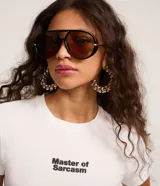Remera blanca de algodón con corte ajustado al cuerpo, cuello redondo y manga corta. Presenta el texto "Master of Sarcasm" estampado en negro en el pecho.