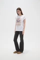 Remera de algodón blanca con estampado frontal de mariposa y texto decorativo en tonos pasteles, de manga corta con dobladillo y calce holgado.