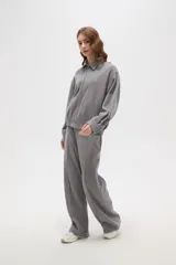 Campera de estilo deportivo en color gris, con cuello solapa, cierre frontal completo y mangas largas con puños ajustados. Presenta un diseño holgado con cintura elástica.