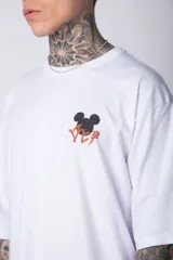 Remera negra de algodón de corte oversize, con mangas cortas y cuello redondo. Estampado pequeño en el frente y diseño grande en la espalda con Mickey Mouse y caracteres orientales en tonos rojizos.