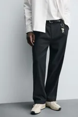 Pantalón de corte relaxed fit confeccionado en mezcla de algodón y modal. Presenta cintura con pliegues frontales, bolsillos laterales y bolsillos traseros con solapa. Cierre frontal con cremallera y botón.