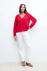 Blusa roja con textura de lunares, escote en V y mangas largas abullonadas.
