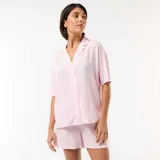 Conjunto de pijama de dos piezas en color rosado y blanco con diseño de rayas verticales, compuesto por una camisa de manga corta con solapas y botones frontales, y un pantalón corto a juego.