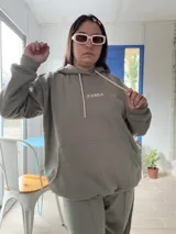 Canguro deportivo de tela suave con logo bordado, diseño holgado y mangas largas.