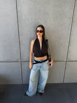 Top negro de cuello halter con escote pronunciado y diseño cruzado en el frente, corte corto.