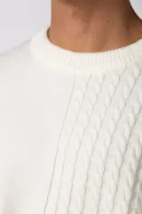 Sweater de punto color blanco con diseño asimétrico, presentando una mitad lisa y la otra mitad con textura de trenzas verticales. Posee cuello redondo y mangas largas con terminación en puño.