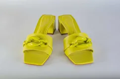 Sandalias tipo sueco color amarillo, con taco ancho y aplique de cadena en el empeine.