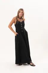 Vestido largo de denim fino y liviano color negro, de breteles finos, escote delicado, silueta entallada arriba y falda amplia con bolsillos laterales.