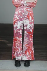 Pantalón palazzo de crepe de seda estampado con motivos florales en tonos fucsia, rojo y blanco. Tiene cierre invisible lateral y costura francesa.