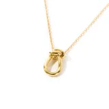 Collar dorado con dije en forma de nudo.