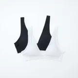 Pack de dos bralettes de microfibra acanalada, uno blanco y otro negro, sin costuras y con breteles anchos.