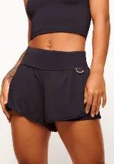 Short deportivo negro con cintura ancha y logo de la marca en el lateral. Incluye short interno de poliamida con bolsillos laterales, detalle reflectivo y cinta funcional.