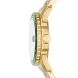 Reloj Fossil de estilo diver con caja y pulsera de acero inoxidable en tono dorado. Presenta una esfera verde con índices luminiscentes, ventana de calendario y bisel giratorio unidireccional a juego.
