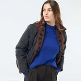 Chaqueta marrón con estampado animal print negro, cuello clásico y cierre con botones.