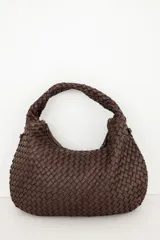 Bolso tipo hobo de cuero marrón oscuro, con diseño trenzado y asa integrada al hombro.