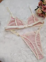 Conjunto de lencería compuesto por un corpiño triangular y una bombacha tipo tanga, confeccionados en algodón color salmón con detalles de puntilla en tono champagne.