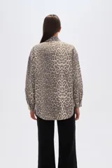 Chaqueta de algodón con estampado de leopardo en tonos grises y beige, corte ancho tipo camisa (shacket), con cuello camisero, botones frontales y bolsillos de parche en el pecho.