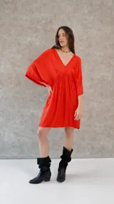 Vestido corto color beige, de raso, con escote en V y mangas 3/4. Corte holgado.