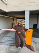 Conjunto deportivo de dos piezas en color marrón chocolate, compuesto por un buzo con capucha de corte cropped y un pantalón de estilo wide leg con bolsillos laterales tipo cargo.