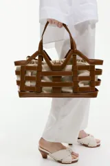 Bolso tipo tote grande de tela revestida marrón con estructura exterior trenzada imitando cuero y bolsa interior de lona de algodón y lino con cordón ajustable.