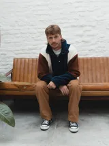 Buzo afelpado de hombre con diseño color block en marrón, azul y blanco.