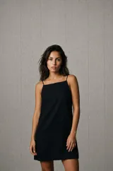 Vestido corto negro de corte recto, con escote cuadrado y tirantes finos.