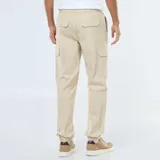 Pantalón cargo color beige, de corte estándar, con múltiples bolsillos laterales y cintura elástica con cordón ajustable.