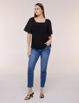 Blusa de corte holgado color marfil, confeccionada en mezcla de modal y algodón, con escote cuadrado y mangas cortas adornadas con detalles de puntilla calada.